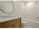 Bright bathroom featuring wood vanity with a marble countertop, a large mirror and a bathtub at 912 Oak Dr, Woodstock, GA 30189