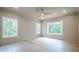 A well-lit bedroom features wood floors, three windows, and a ceiling fan at 912 Oak Dr, Woodstock, GA 30189