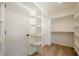 A walk-in closet offers white shelves and hanging storage with wood laminate floors at 912 Oak Dr, Woodstock, GA 30189