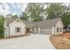 Charming single-Gathering home with white siding, stone accents, attached garage and concrete driveway at 912 Oak Dr, Woodstock, GA 30189