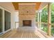 Covered back porch has wood floors and a brick fireplace with a stained wood mantel at 912 Oak Dr, Woodstock, GA 30189