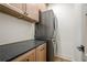 Laundry room features a stacked washer and dryer, black countertop and wood cabinets at 912 Oak Dr, Woodstock, GA 30189