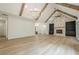 Open living area with hardwood floors, wood beam ceiling, fireplace, and access to kitchen at 912 Oak Dr, Woodstock, GA 30189