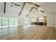 Open living area featuring wood beams, a view of the backyard, kitchen, and hardwood floors at 912 Oak Dr, Woodstock, GA 30189