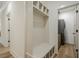 Bright mudroom featuring a storage bench and entry to a laundry room with wood-look floors at 912 Oak Dr, Woodstock, GA 30189