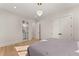 Bright bedroom with hardwood floors, modern lighting, and a glimpse into the bathroom at 1336 Azalea Dr, Lawrenceville, GA 30043