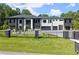 Modern home featuring black stone accents, a white facade, large windows, and a wrought iron fence at 1336 Azalea Dr, Lawrenceville, GA 30043