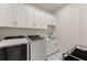 Well-equipped laundry room with modern washer, dryer, cabinets, sink and eye-catching floor at 1336 Azalea Dr, Lawrenceville, GA 30043
