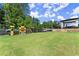 Spacious backyard featuring a well-maintained lawn, playset, and secure fencing at 1336 Azalea Dr, Lawrenceville, GA 30043