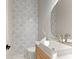 Stylish powder room featuring unique mosaic tile, modern sink, and elegant mirror, perfect for guests' convenience at 1336 Azalea Dr, Lawrenceville, GA 30043