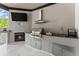 Well-equipped summer kitchen under a covered patio, featuring stainless steel appliances and a cozy fireplace at 1336 Azalea Dr, Lawrenceville, GA 30043
