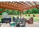 Outdoor patio under a pergola with grill, table, and chairs, overlooking large backyard and shed at 2420 Westport Cir, Marietta, GA 30064
