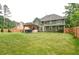 Green backyard featuring a wood fence, patio, and green two story home at 2420 Westport Cir, Marietta, GA 30064