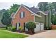 Two-story home with a brick facade, attached garage, and well-maintained landscaping on a green lawn at 2420 Westport Cir, Marietta, GA 30064