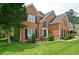 Two-story brick house with green lawn, mature trees, and well-maintained landscaping for inviting curb appeal at 2420 Westport Cir, Marietta, GA 30064