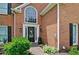 Inviting brick home entrance featuring a black front door, arched window, and neatly landscaped garden at 2420 Westport Cir, Marietta, GA 30064