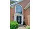 Inviting entrance to a brick home with a black door, large arched window, and well-maintained landscaping at 2420 Westport Cir, Marietta, GA 30064