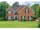 Charming two-story brick home with a manicured lawn, complemented by black shutters and lush landscaping at 2420 Westport Cir, Marietta, GA 30064
