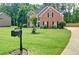 Spacious front yard of a brick home, featuring a green lawn, mailbox, and mature trees, conveying curb appeal at 2420 Westport Cir, Marietta, GA 30064
