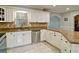 Well-lit kitchen featuring granite countertops, stainless dishwasher, and ample cabinet space at 2420 Westport Cir, Marietta, GA 30064