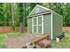 A backyard storage shed with a wooden deck and painted white trim against a forest backdrop at 2420 Westport Cir, Marietta, GA 30064
