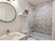 Bright bathroom featuring marble tiled shower, modern sink, round mirror, and white countertop at 429 Deckner Sw Ave, Atlanta, GA 30310