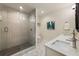 Modern bathroom featuring a glass-enclosed shower, double sinks, and unique geometric tile flooring at 429 Deckner Sw Ave, Atlanta, GA 30310
