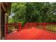 View of the spacious red-painted deck with stairs to the yard and a natural surrounding, perfect for outdoor enjoyment at 429 Deckner Sw Ave, Atlanta, GA 30310
