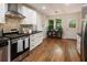A well-lit kitchen offers stainless steel appliances, white cabinets and doors, and wood-look flooring at 429 Deckner Sw Ave, Atlanta, GA 30310