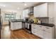 Modern kitchen featuring stainless steel appliances, white cabinets, and black countertops and adjacent dining area at 429 Deckner Sw Ave, Atlanta, GA 30310