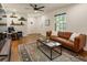 Bright living room boasts hardwood floors, a leather sofa, and decoratively styled floating shelves at 429 Deckner Sw Ave, Atlanta, GA 30310