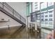 Bright living room with a modern staircase, a white table with chairs, and large windows with city views at 845 Spring Nw St # 307, Atlanta, GA 30308