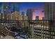 View from a spacious balcony, featuring a wrought iron railing and city skyline at dusk at 195 14Th St # 902, Atlanta, GA 30309