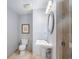 Cozy bathroom featuring a toilet, pedestal sink, decorative mirror and tiled shower at 195 14Th St # 902, Atlanta, GA 30309