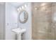 Modern bathroom with a pedestal sink, decorative mirror, and glass enclosed shower with decorative tile at 195 14Th St # 902, Atlanta, GA 30309