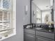 Stylish bathroom with a granite vanity, gray cabinetry, and a window offering natural light at 195 14Th St # 902, Atlanta, GA 30309