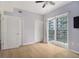 Bright bedroom with light hardwood floors and a sliding glass door that leads to a balcony at 195 14Th St # 902, Atlanta, GA 30309