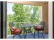 Cozy balcony with a small table and chairs offering a relaxing outdoor space surrounded by lush greenery at 211 Colonial Homes Nw Dr # 2501, Atlanta, GA 30309