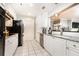 Modern kitchen featuring white cabinets, stainless steel appliances, granite countertops and white tile floors at 211 Colonial Homes Nw Dr # 2501, Atlanta, GA 30309