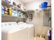 Well-lit laundry room featuring a washer, dryer, and shelving for storage at 211 Colonial Homes Nw Dr # 2501, Atlanta, GA 30309