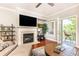 Bright living room featuring a fireplace, balcony access, hardwood floors, and neutral color palette at 211 Colonial Homes Nw Dr # 2501, Atlanta, GA 30309