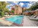 Community pool surrounded by lounge chairs and umbrellas with brick buildings in the background at 211 Colonial Homes Nw Dr # 2501, Atlanta, GA 30309