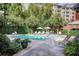 Relaxing pool area surrounded by lush greenery, lounge chairs, and shade umbrellas at 211 Colonial Homes Nw Dr # 2501, Atlanta, GA 30309