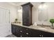 Dual sink bathroom with granite counters, dark wood cabinets, and two mirrors at 345 Alderwood Ln, Sandy Springs, GA 30328