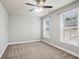 Bedroom features neutral carpet, modern ceiling fan, and good natural lighting from large windows at 345 Alderwood Ln, Sandy Springs, GA 30328
