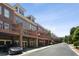 Row of brick townhomes with garages, covered patios, and balconies along tree-lined street at 345 Alderwood Ln, Sandy Springs, GA 30328
