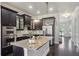 Eat-in kitchen features dark cabinetry, stainless steel appliances, granite countertops, and an oversized island at 345 Alderwood Ln, Sandy Springs, GA 30328