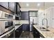 Modern kitchen with dark cabinets, stainless steel appliances, granite countertops, and an island with a sink at 345 Alderwood Ln, Sandy Springs, GA 30328
