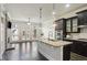 Open-concept kitchen and living space with dark wood floors, brick fireplace and access to the outdoor deck at 345 Alderwood Ln, Sandy Springs, GA 30328