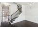 Staircase with wood and iron railings leading upstairs with a modern chandelier at 345 Alderwood Ln, Sandy Springs, GA 30328